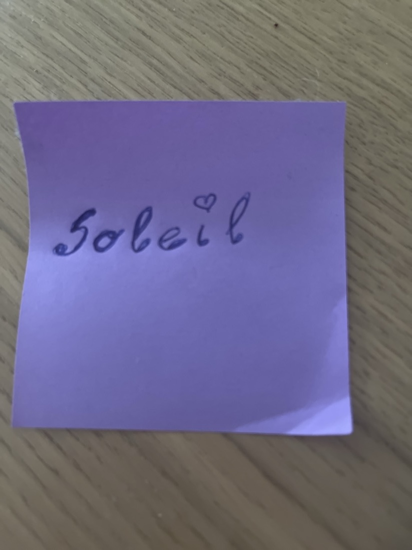 A purple Post-it note with the word Soleil written on it, and a small hand-drawn heart